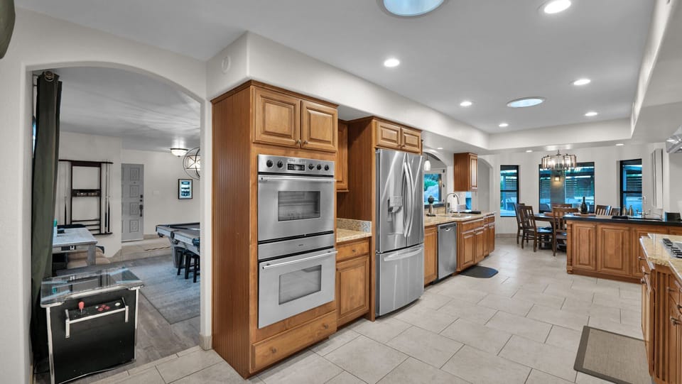 Modern chef's kitchen flows into the exciting game room with billiards & arcade.
