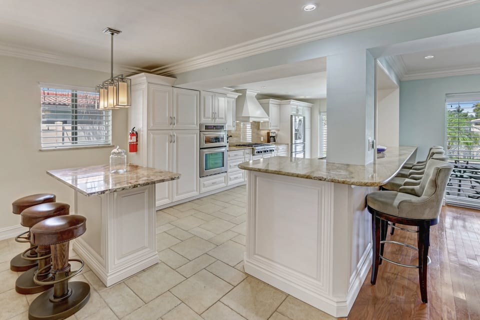 Kitchen peninsula & island feature numerous counter stools -sit added guests-