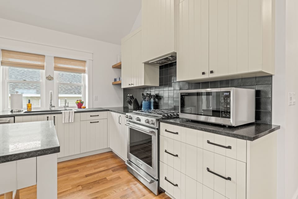 Gas range & oven; handmade kitchen tile backsplash & custom-built cabinets