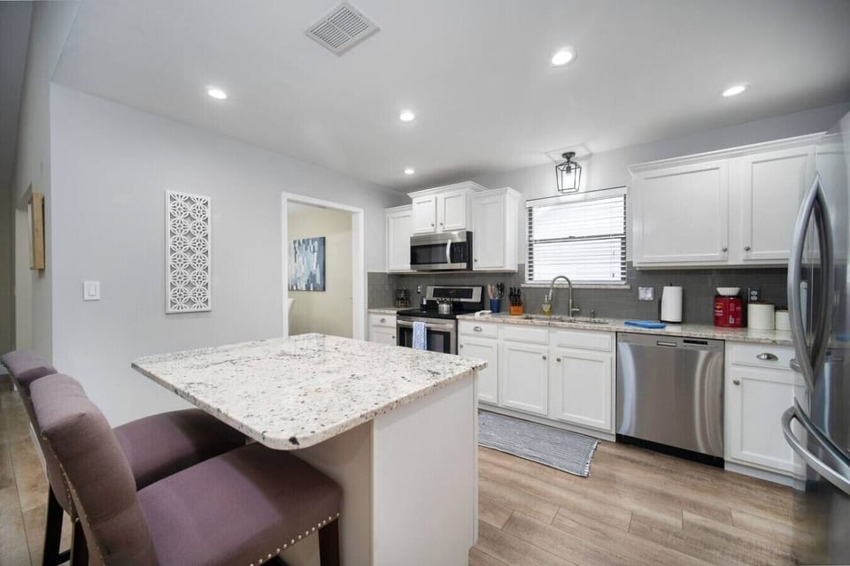 Bright kitchen with a breakfast bar, sleek finishes, and plenty of space for dining and cooking.