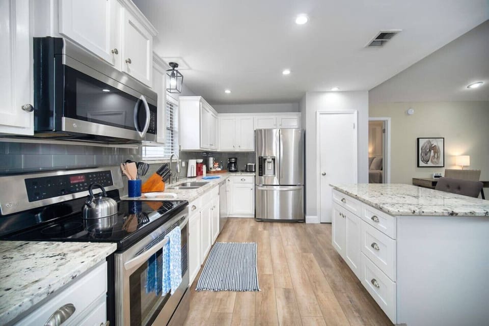 Modern kitchen with stainless steel appliances, granite countertops, and ample prep space.