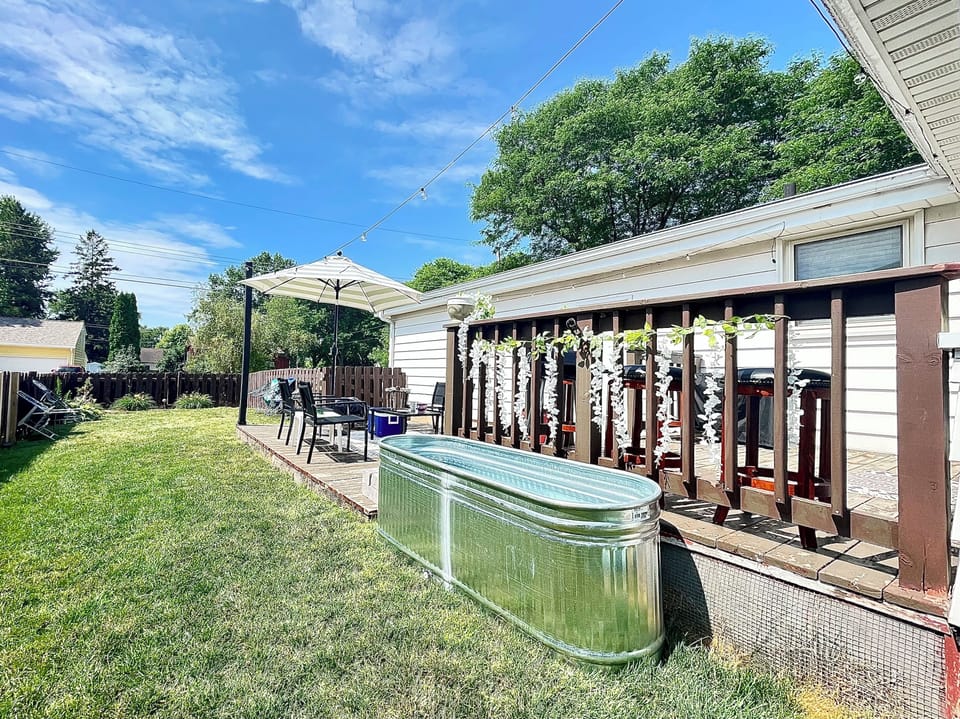 Cold plunge next to two-tier patio area with fire pit, grill, and seating area