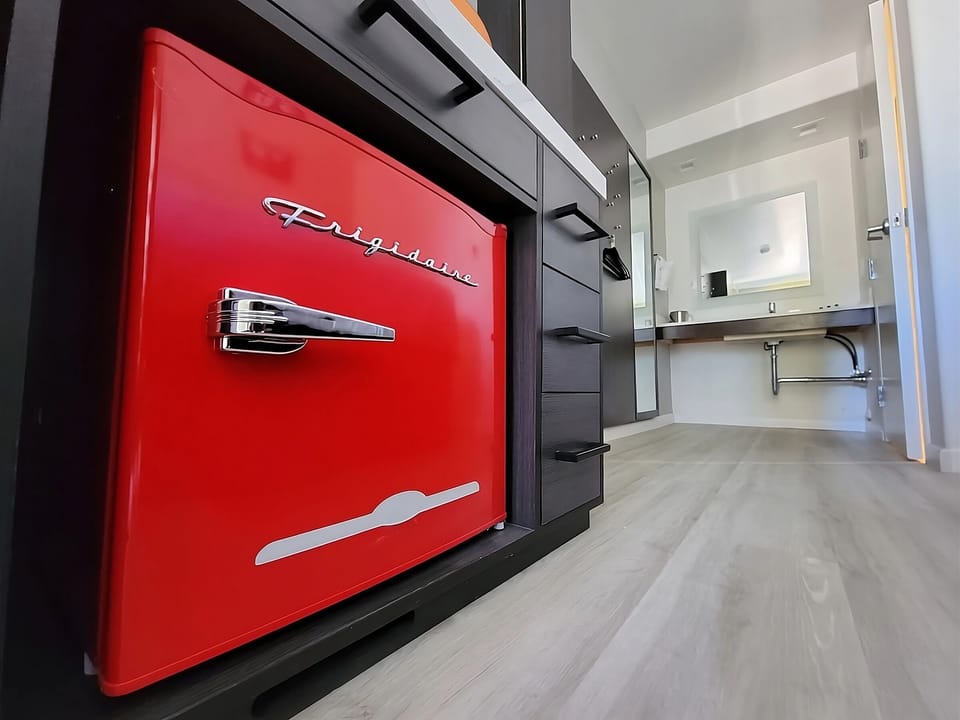 Enjoy quick snacks with stylish fridge and modern kitchenette.
