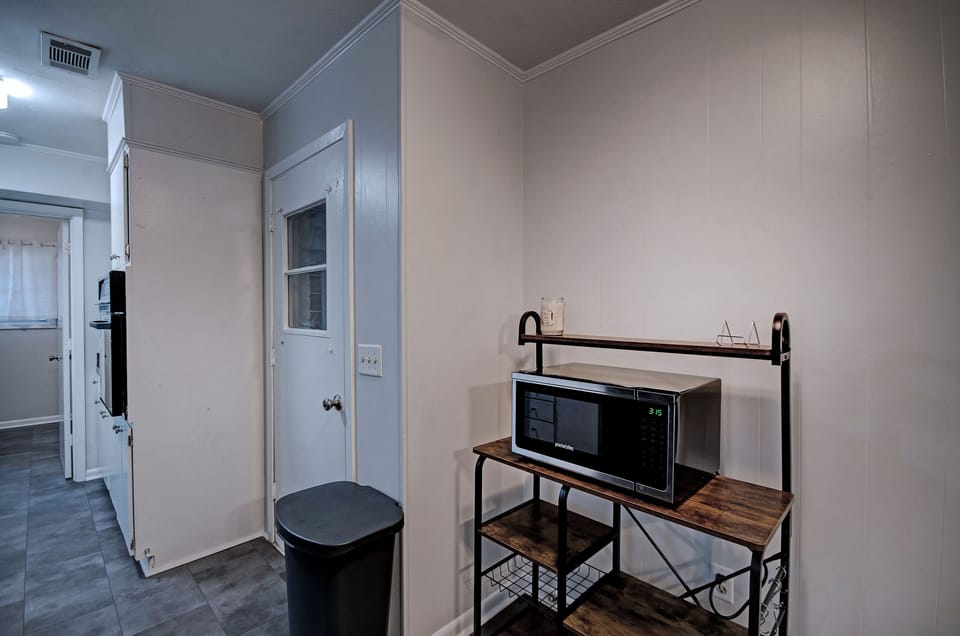 The kitchen with a microwave and storage area. The garage door is off of the kitchen.