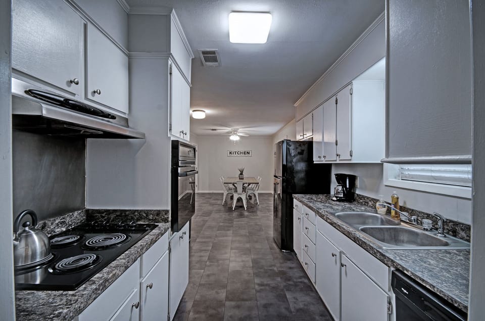 Kitchen with a stove, oven, refrigerator, dishwasher, microwave, 12-cup programmable coffee pot, and crock pot. Great for long stays.