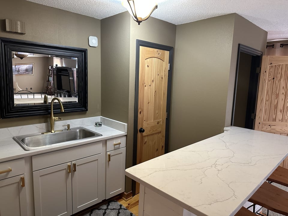 Newly installed wet bar area (completed 4/23). Bar stool seating around island.