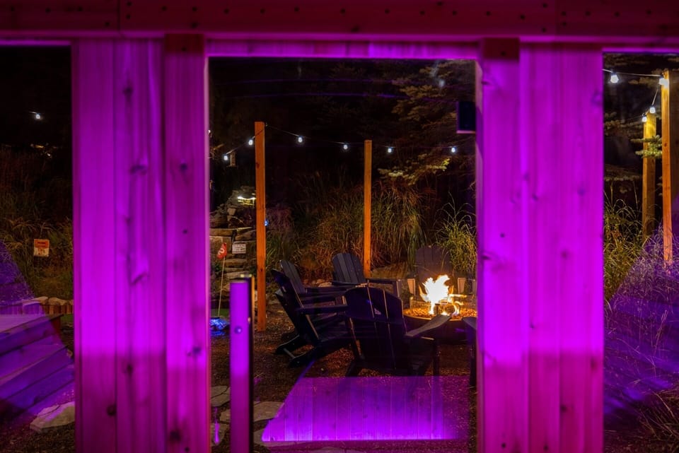 View from the sauna 🔥 Step inside our 6-person cube sauna with glowing lights and enjoy the firepit vibes just outside the window. Relax, recharge & soak in the night magic.
