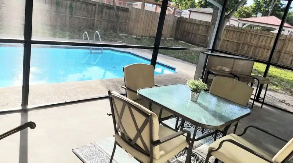 Screened sunroom with dining and bar.