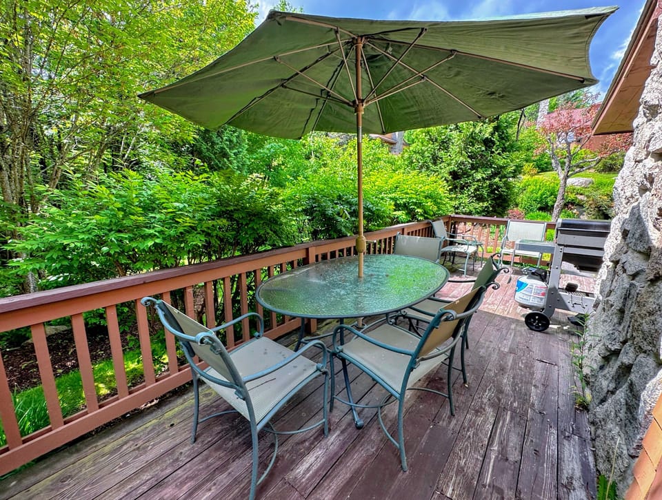 Deck has a dining table and propane grill