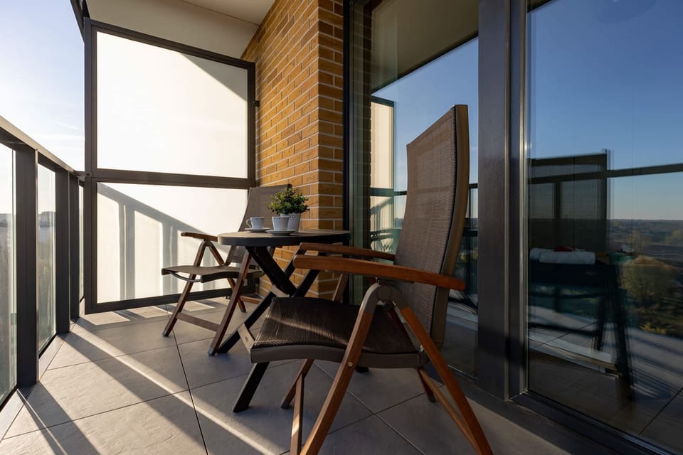 A private balcony equipped with a small table and chairs, perfect for enjoying morning coffee or evening relaxation.