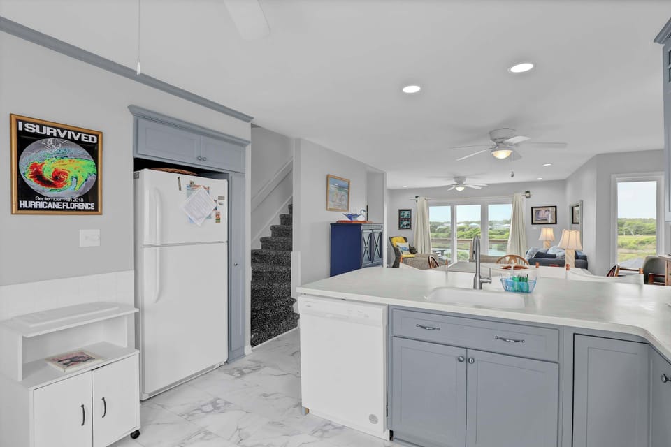 Indulge in the essence of coastal living within the chic kitchen of this townhouse. An ideal setting to craft delightful memories during your seaside getaway.