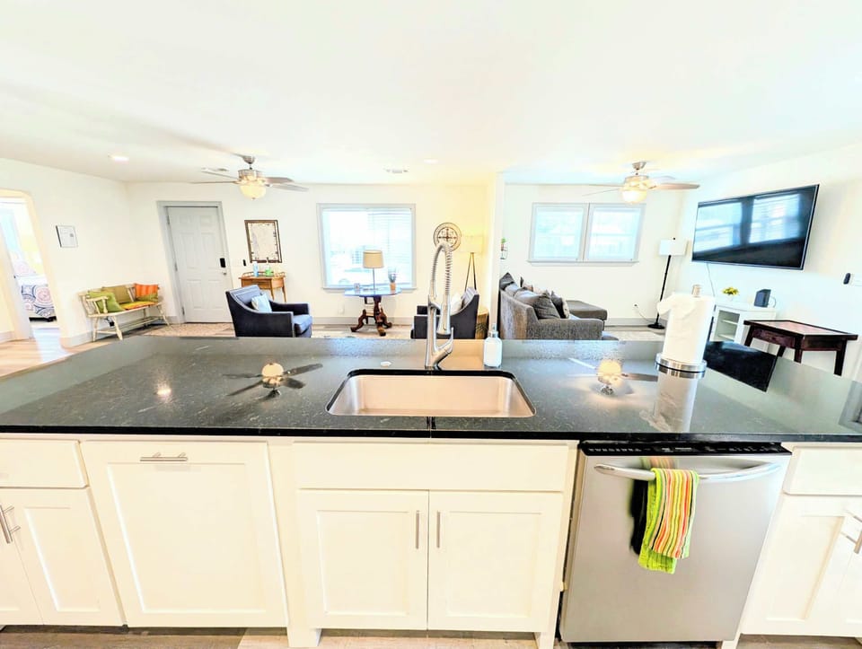 Large kitchen bar with dishwasher overlooking the living space.