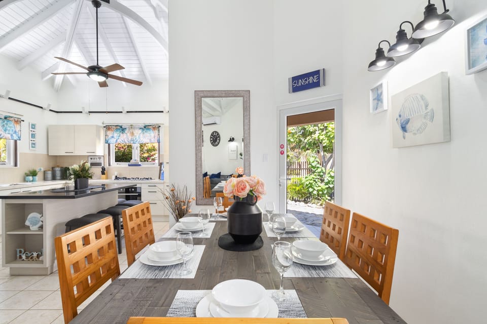 Marvelous dinning area of the 2BR Home in Noord, Aruba - Beautiful dinning area along with open kitchen - Elite 6 persons dinning - Stunningly located large glass door with mesmerizing views - Majestic decored with beautiful paintings and wall lamps