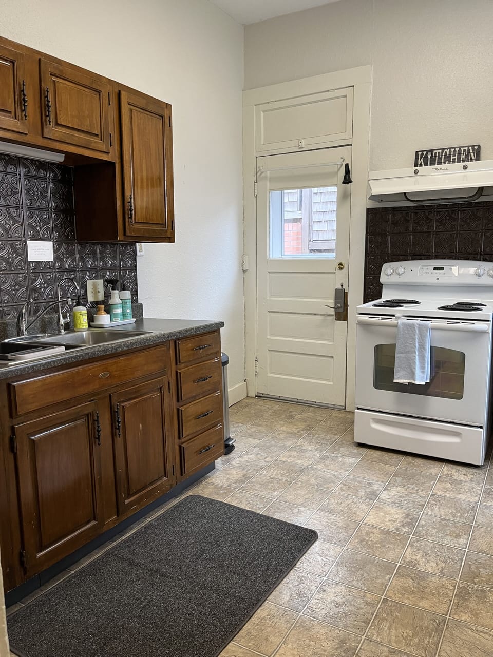 Kitchen with stove, refrigerator, microwave, water filter and tableware