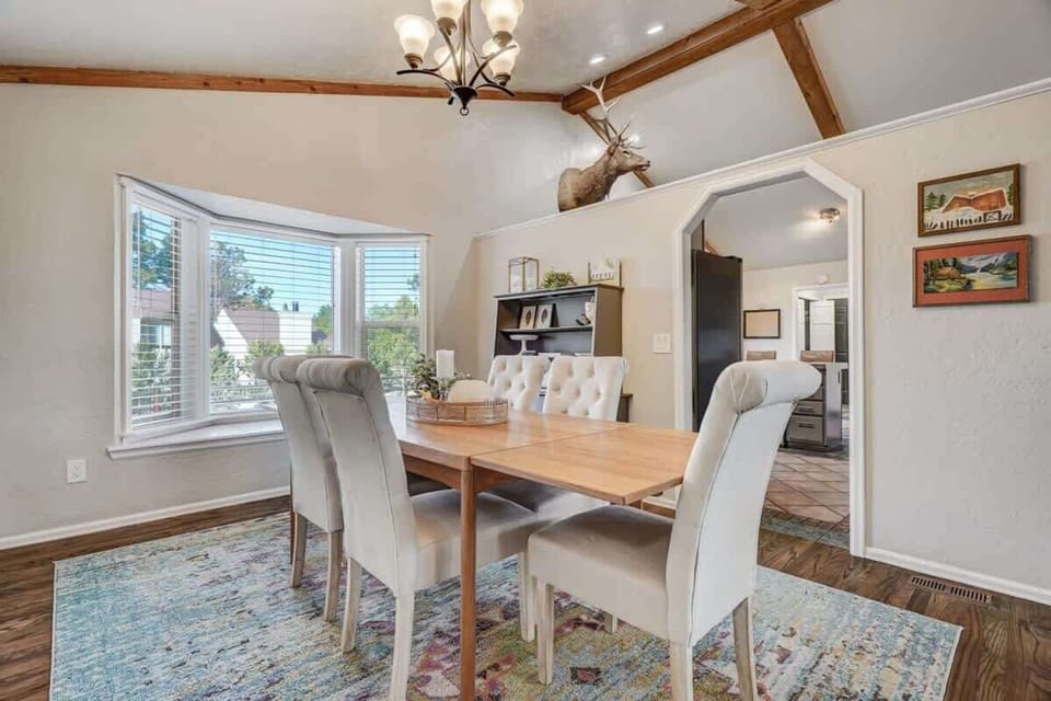 Bright dining space with plush seating, a large bay window, and rustic touches—perfect for shared meals and conversation.

