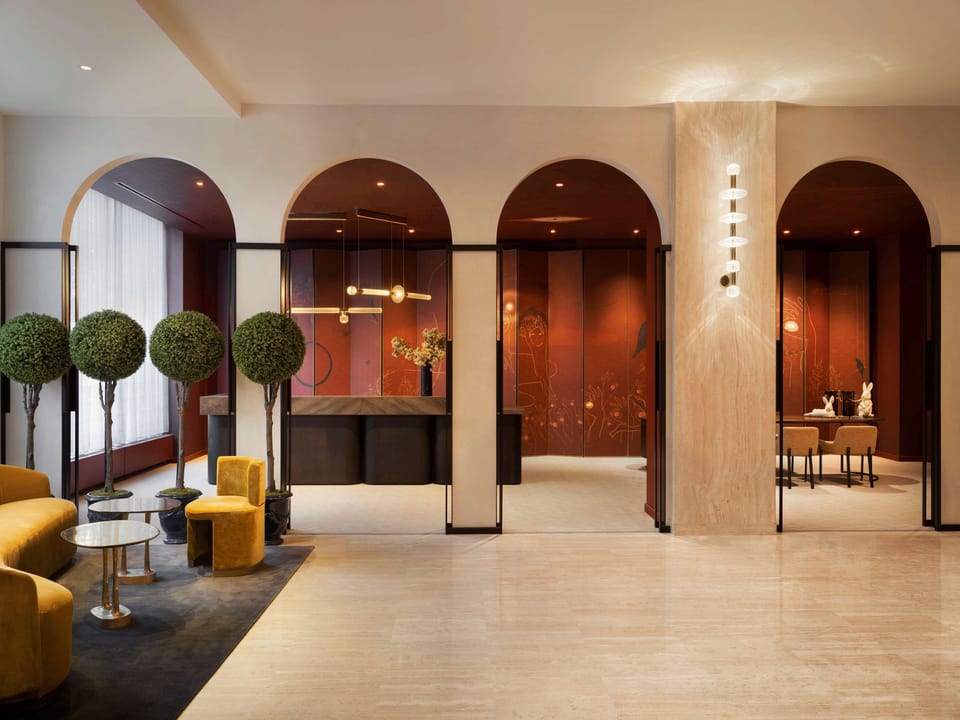 Arrive to a grand lobby with arches and warm light.