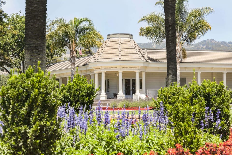 Stroll past blooming gardens toward a charming clubhouse entrance.