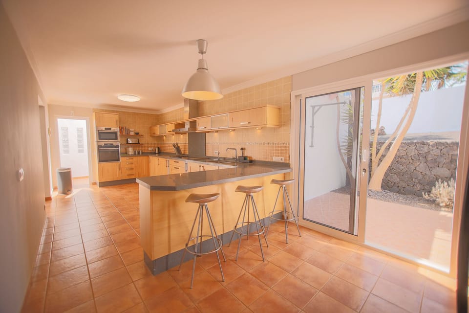 Bright kitchen with quality knives, dishwasher, breakfast bar, and stove