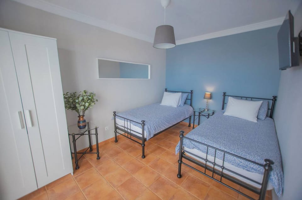 Bright room with 2 single beds, pool outlook, and built-in storage