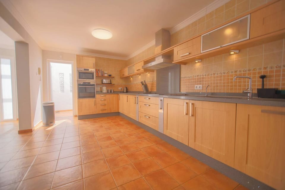 Spacious kitchen with electric stove, breakfast bar, and all cooking essentials