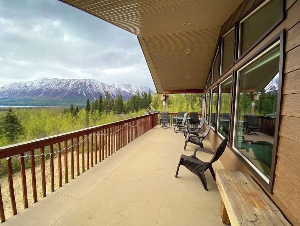Upper deck area has table and chairs, additional outdoor chairs and a gas grill