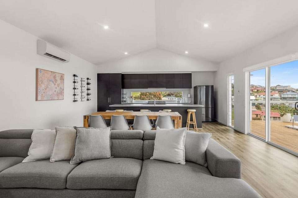 The living room`s sleek gray and white theme creates a sophisticated and calming atmosphere, perfect for relaxation and socializing.