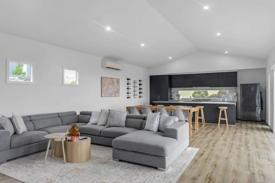 This beautifully designed living room features a gray and white theme, with the fireplace adding a touch of rustic charm and warmth to the space.