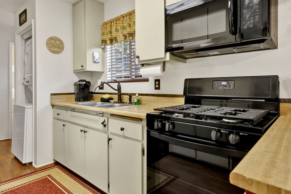 Fully equipped cabin kitchen with ample cabinetry, stove, fridge, microwave, and coffee maker—perfect for cooking meals, morning coffee, and feeling right at home on your stay.