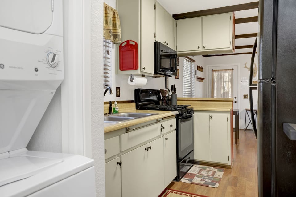 Fully equipped cabin kitchen with ample cabinetry, stove, fridge, microwave, and coffee maker—perfect for cooking meals, morning coffee, and feeling right at home on your stay.