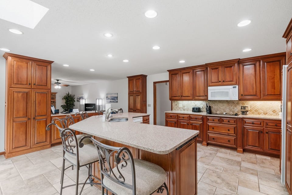 Your gourmet kitchen awaits with rich cherry cabinetry, granite counters, and spacious island perfect for cooking memorable meals together.