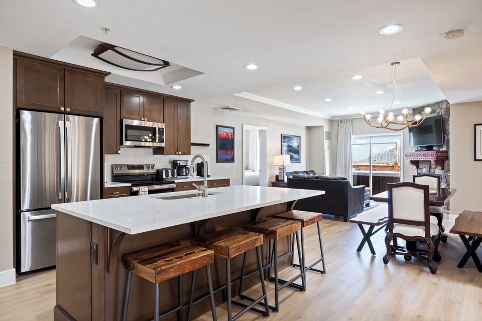 - Kitchen and dining area with rustic wood accents  
- Spacious island with seating for friends and family  
- Comfortable flow into living space with fireplace
