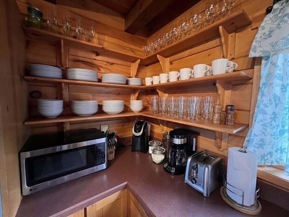 Fully stocked kitchen with 2 coffee makers, toaster, microwave and plates, bowls, glasses, mugs for the entire booking