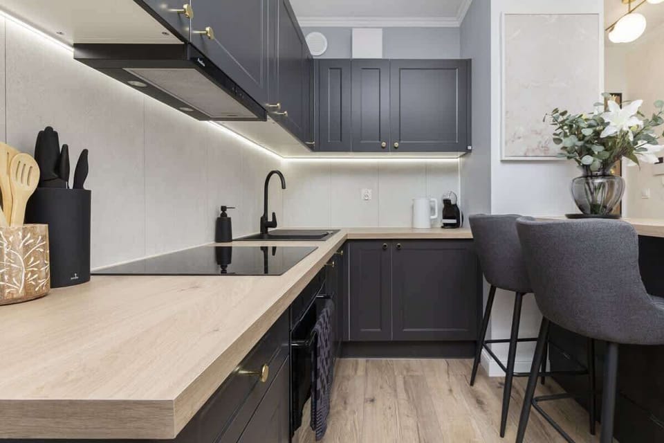 Kitchen with wooden countertop, dark cabinets, and dining area.
