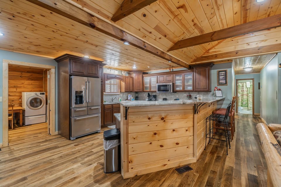 Your rustic kitchen blends mountain charm with modern convenience, featuring rich wood beams and a welcoming island for cooking.