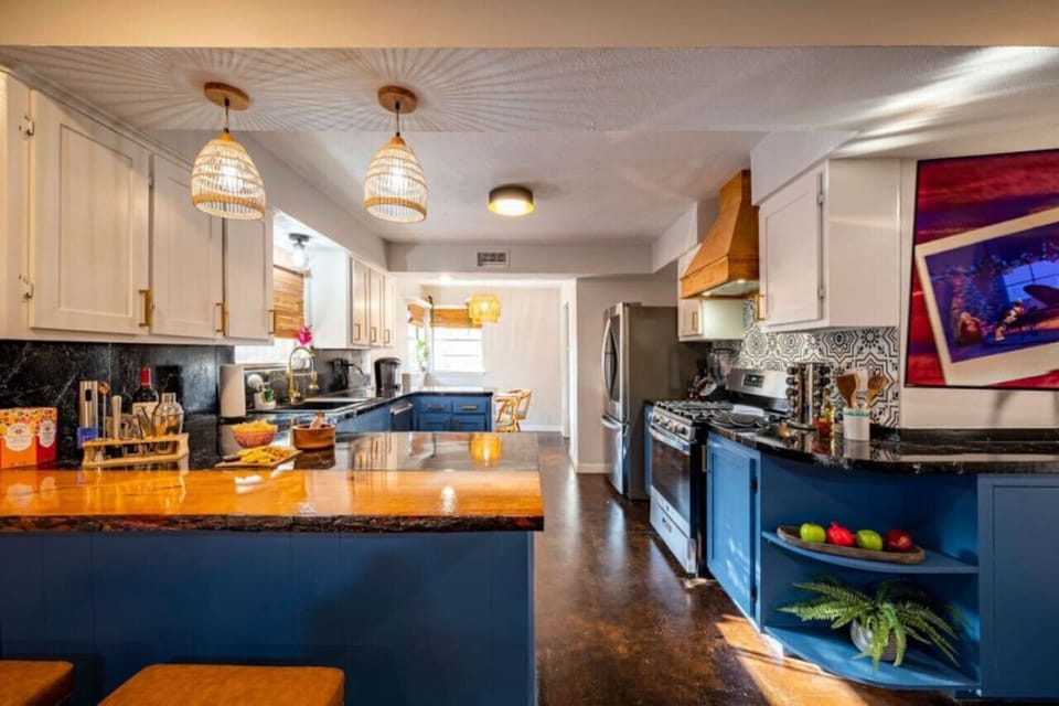 Inviting open layout with bold blue kitchen, cozy seating, and dining area—perfect for entertaining in style.