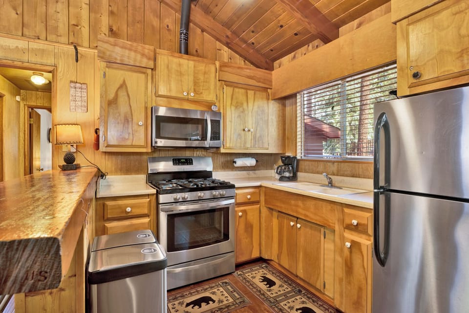Fully equipped cabin kitchen with ample cabinetry, stove, fridge, microwave, and coffee maker—perfect for cooking meals, morning coffee, and feeling right at home on your stay.