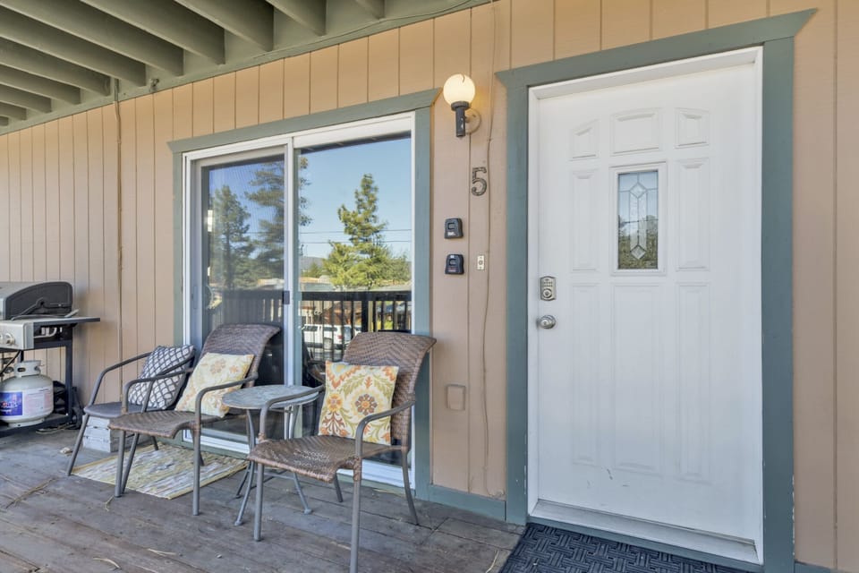 Welcoming cabin entry surrounded by towering pine trees, offering fresh mountain air and a peaceful forest setting—the perfect first impression for your Big Bear Lake getaway.