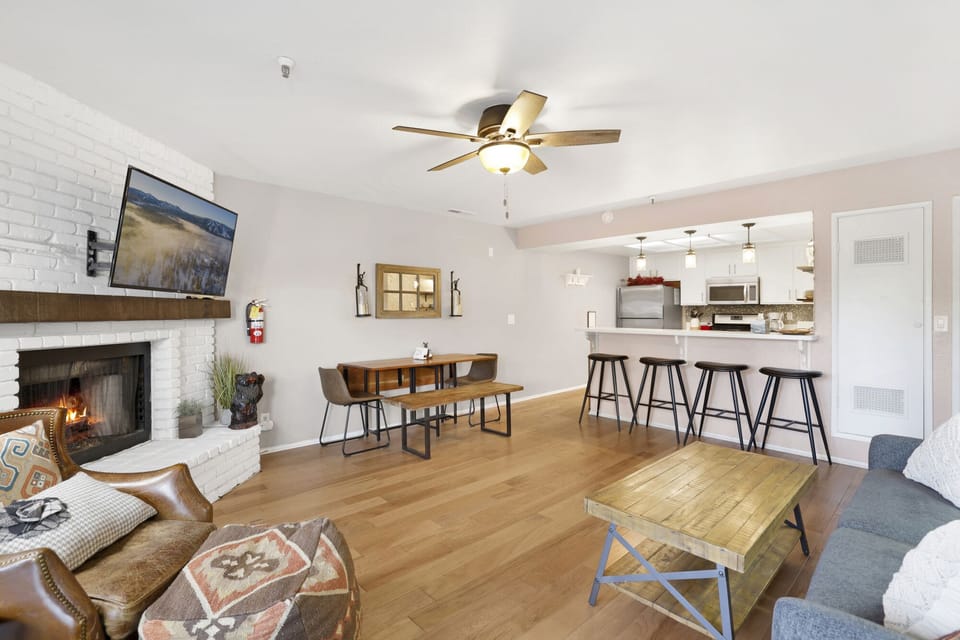 Cozy mountain living room with a fireplace, comfy seating, and smart TV—perfect for relaxing evenings, movie nights, and warm cabin vibes after outdoor adventures.