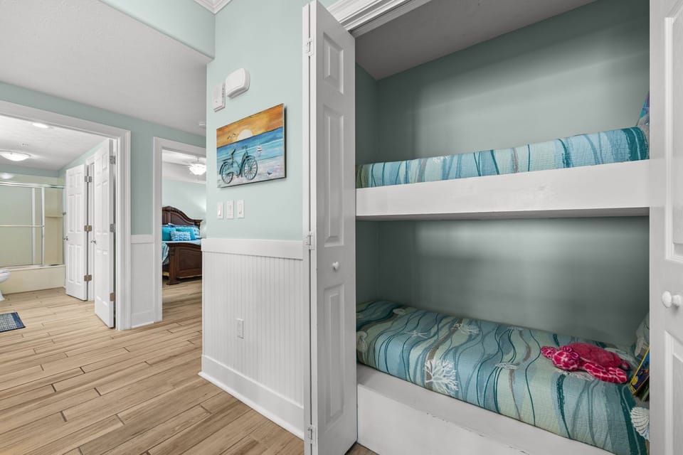 Cozy bunk beds in a softly painted room with beach-themed decor.
