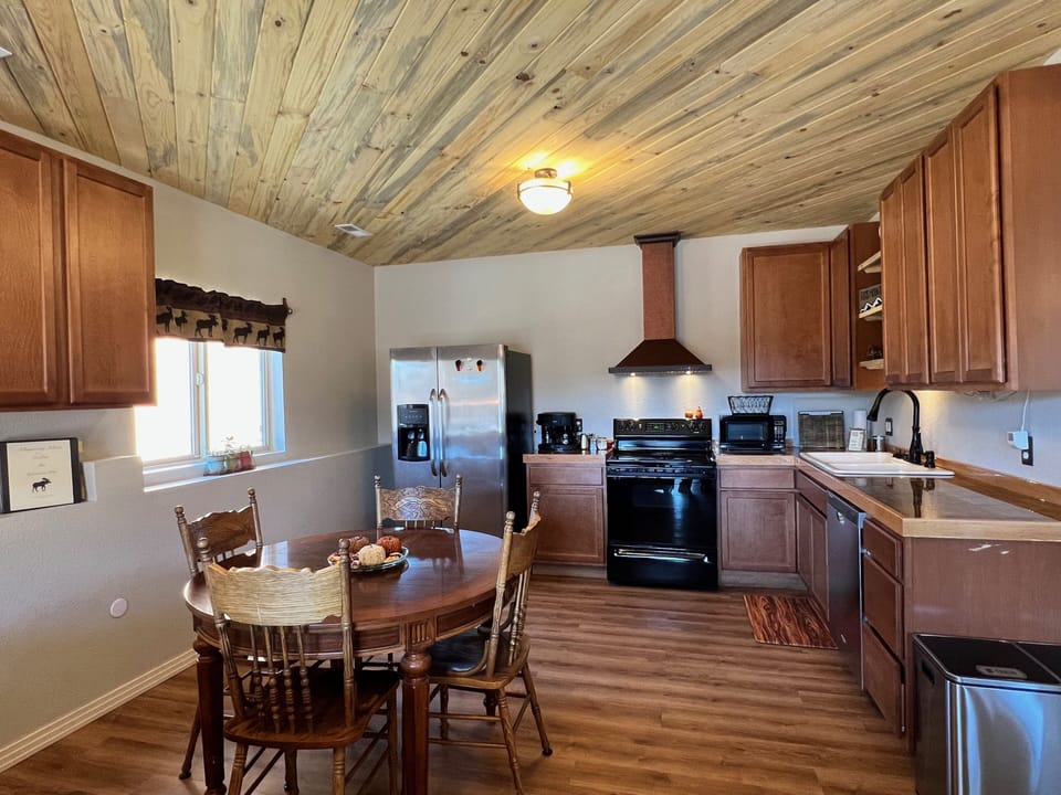 Open and fully stocked kitchen and dining area. Beetle kill pine ceiling.
