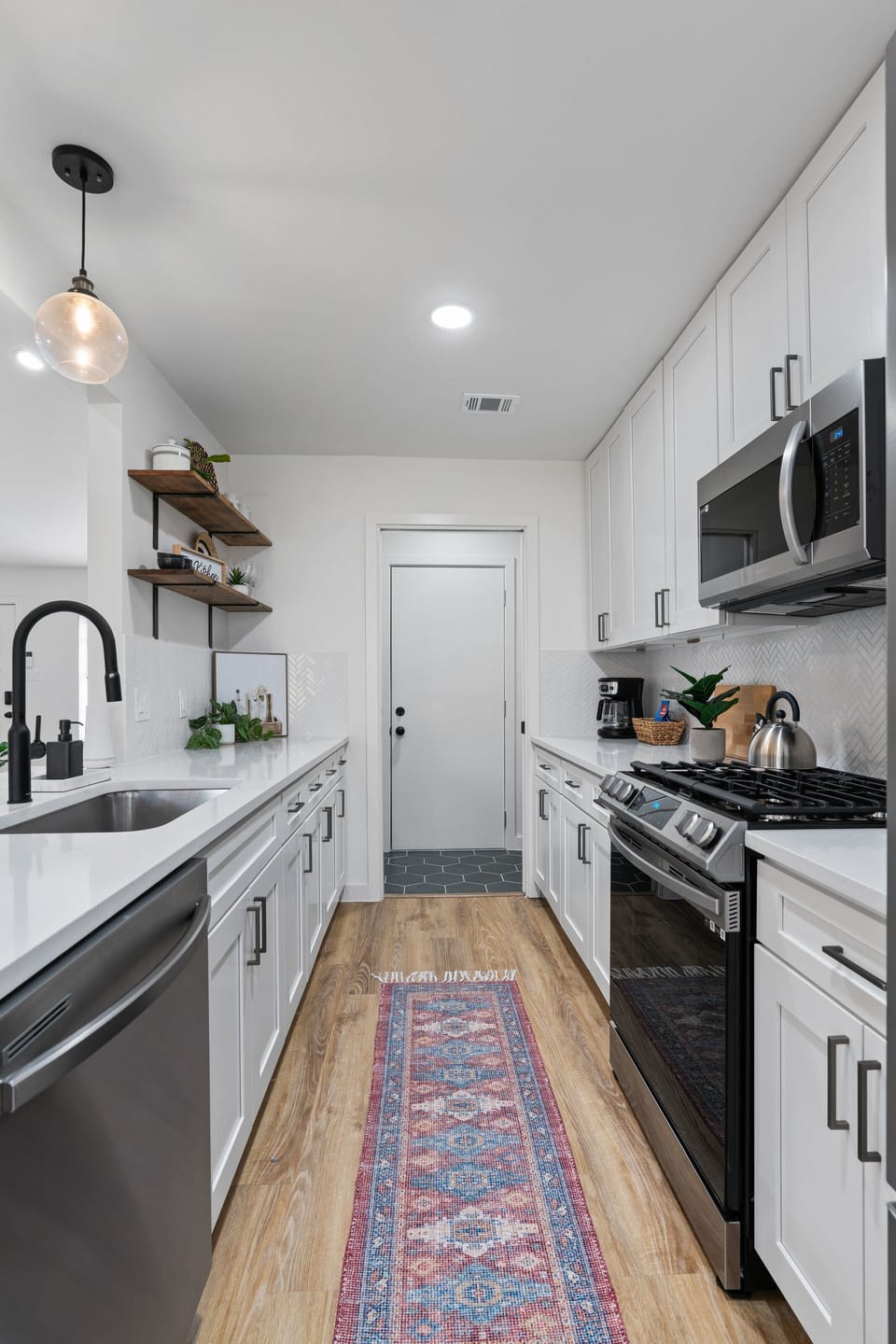 Alley Kitchen leading into the Laundry room/ Pantry/ Garage door