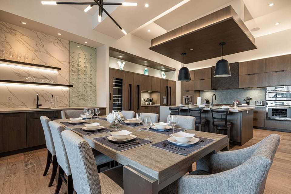Open fully equipped kitchen, and dining area with gas range, stone countertops, and large dining room table with ample seating