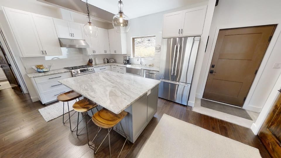 Your dream vacation kitchen awaits—sleek marble counters, stainless appliances, and stylish bar seating create the perfect spot to whip up meals and gather with loved ones.