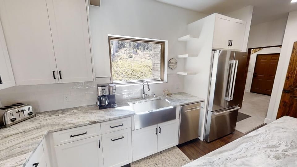 Step into your fully equipped kitchen with modern stainless appliances, elegant countertops, and a bright window for natural light while you cook your favorite meals.