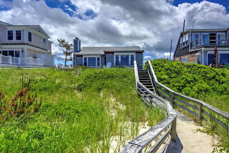 Back of the home with private boardwalk to the beach.