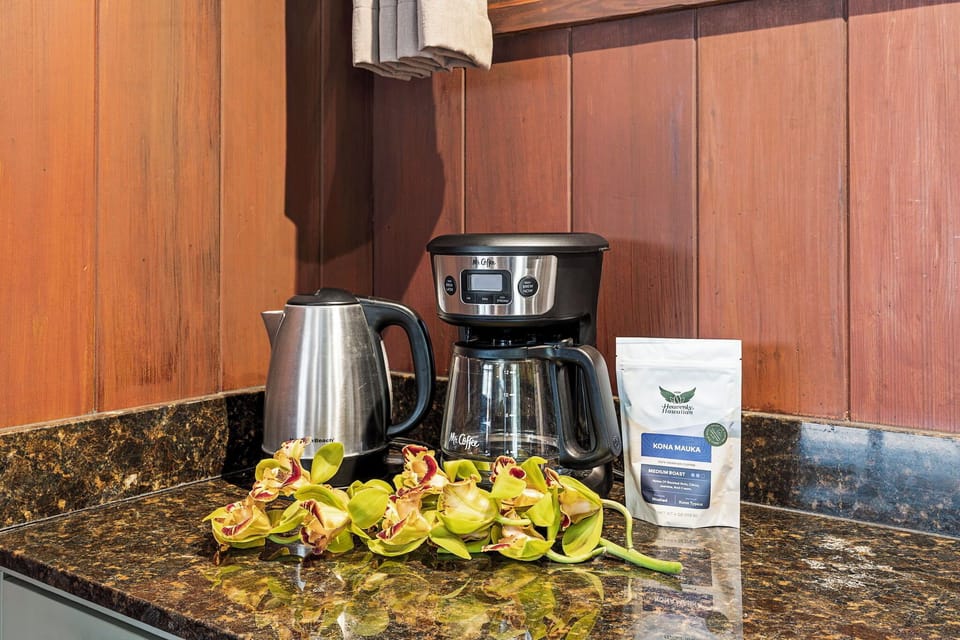 Wake up to the aroma of fresh Hawaiian coffee—your mornings here start with a complimentary kettle, coffee maker, and premium Kona Mauka beans waiting on the counter.