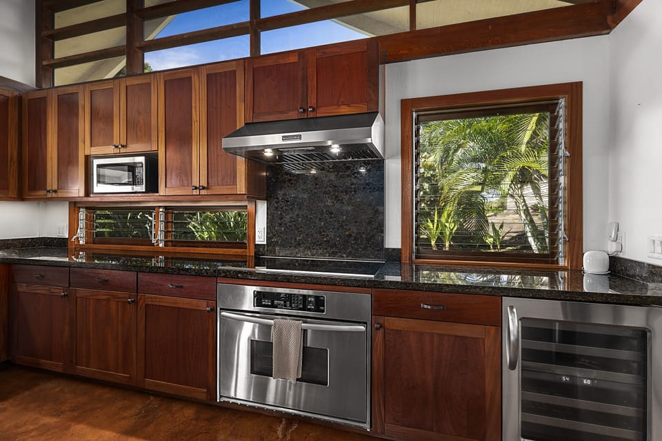 Fully equipped kitchen with stainless steel appliances and garden views.