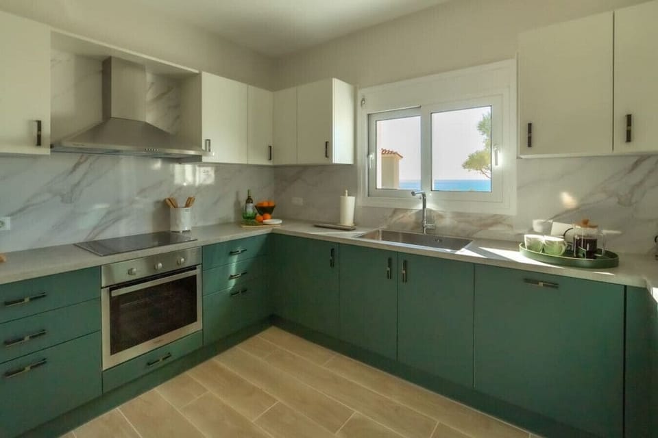 Well-equipped kitchen with dishwasher, laundry machine, and a view of the sea.