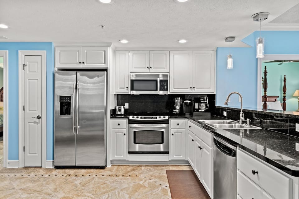 Modern kitchen with stainless steel appliances and black granite countertops