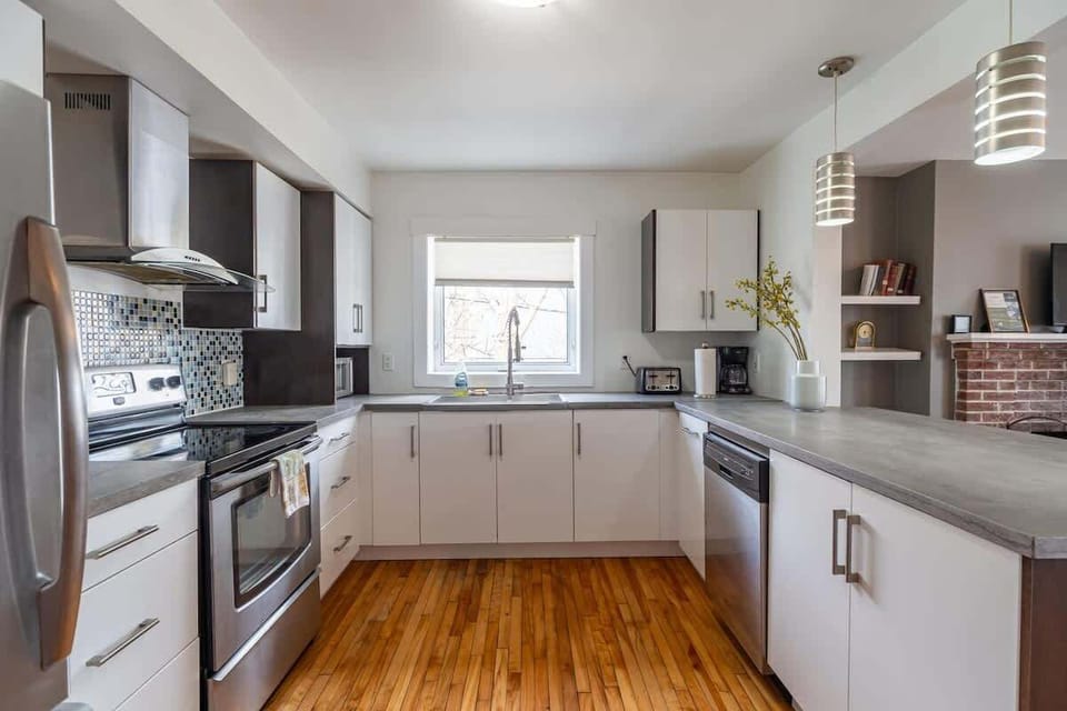 Bright and stylish kitchen with plenty of natural light! Featuring sleek white cabinets and modern appliances.